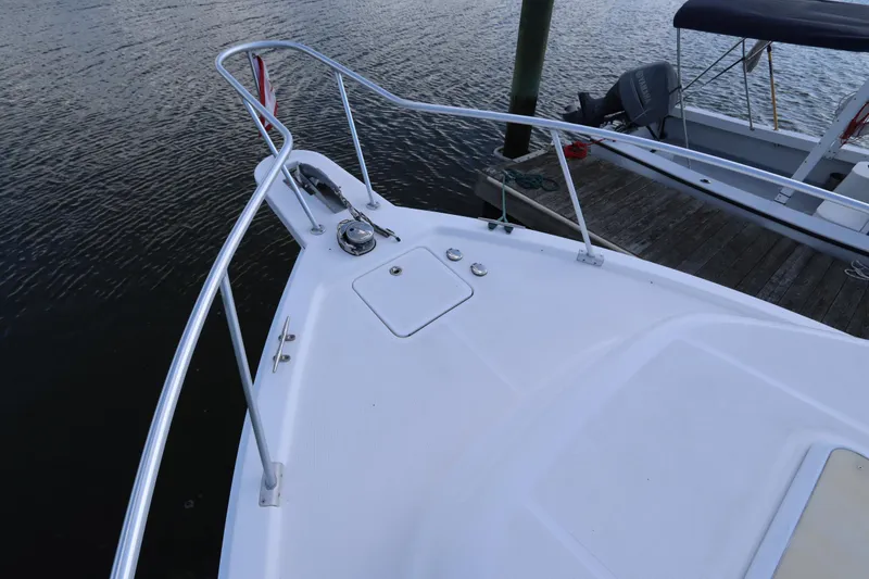 Slide: The Image of 2002 Mainship Pilot 34 boat bow with railing, docked by the water. - 10