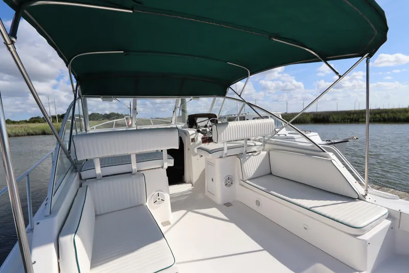 Slide: The Image of 2002 Mainship Pilot 34 boat interior with green canopy and white seating. - 16