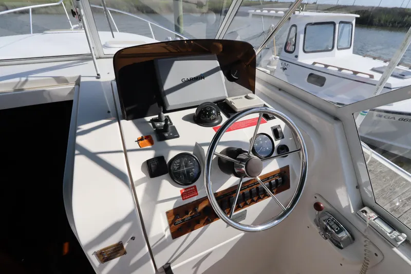 Slide: The Image of 2002 Mainship Pilot 34 helm with steering wheel, gauges, and navigation equipment. - 20
