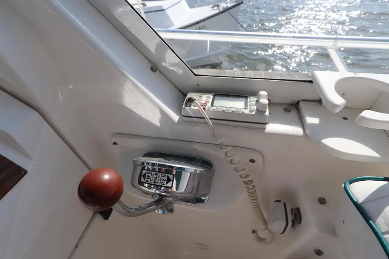 Slide: The Image of 2002 Mainship Pilot 34 boat cockpit with control panel and throttle lever. - 32