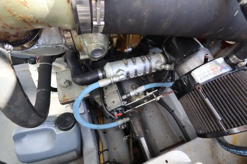 Slide: The Image of Engine compartment of a 2002 Mainship Pilot 34 boat, showcasing mechanical components and hoses. - 35