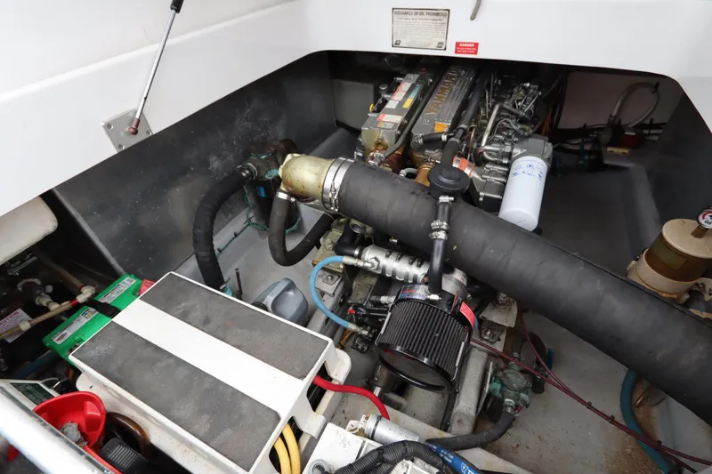 Slide: The Image of Engine compartment of a 2001 Mainship Pilot 34, showcasing mechanical components and hoses. - 36