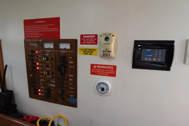 Slide: The Image of Electrical control panel on a 2002 Mainship Pilot 34 boat with warning signs. - 46