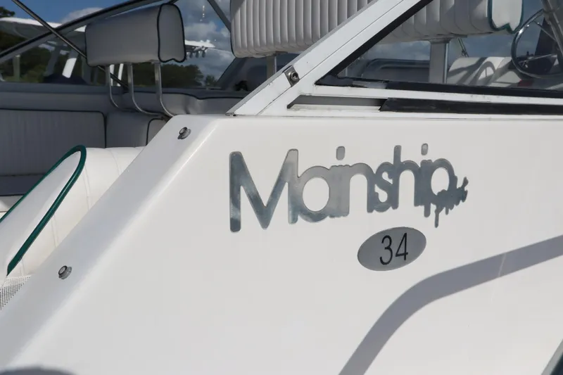 Slide: The Image of 2002 Mainship Pilot 34 boat with logo and seating area. - 5