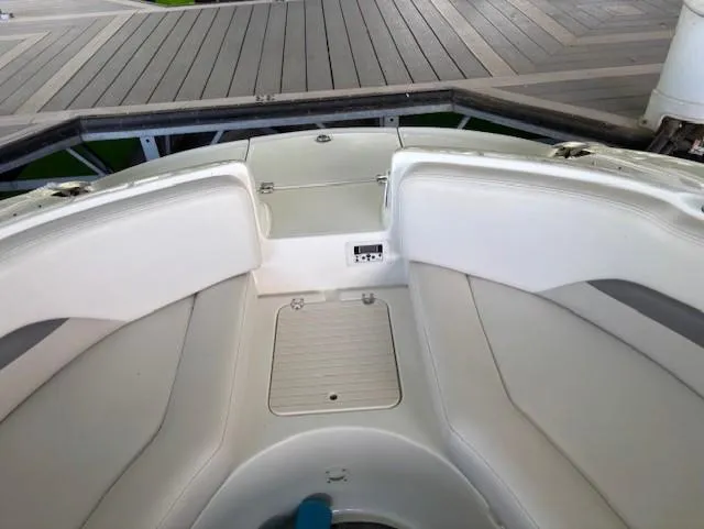 Slide: The Image of 2007 Chaparral Sunesta 274 boat interior with white seating and storage compartments. - 13
