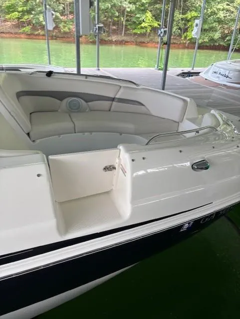 Slide: The Image of 2007 Chaparral Sunesta 274 boat with white seating, docked near green water. - 5