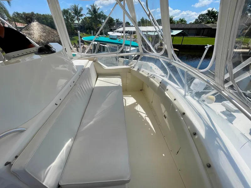 Slide: The Image of 1988 Bertram 43 Convertible boat interior with white seating and clear enclosure. - 11