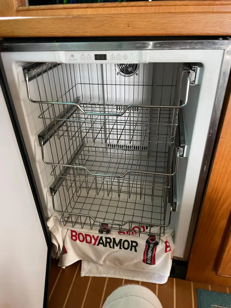Slide: The Image of Empty refrigerator with wire shelves in a 1988 Bertram 43 Convertible boat. - 23