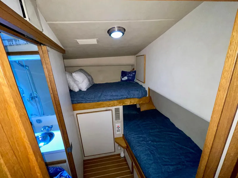 Slide: The Image of 1988 Bertram 43 Convertible cabin with bunk beds and compact bathroom. - 29