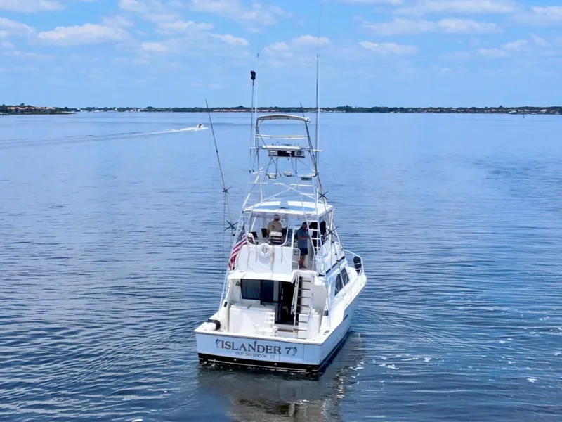 Slide: The Image of 1988 Bertram 43 Convertible boat on calm water under blue sky. - 3