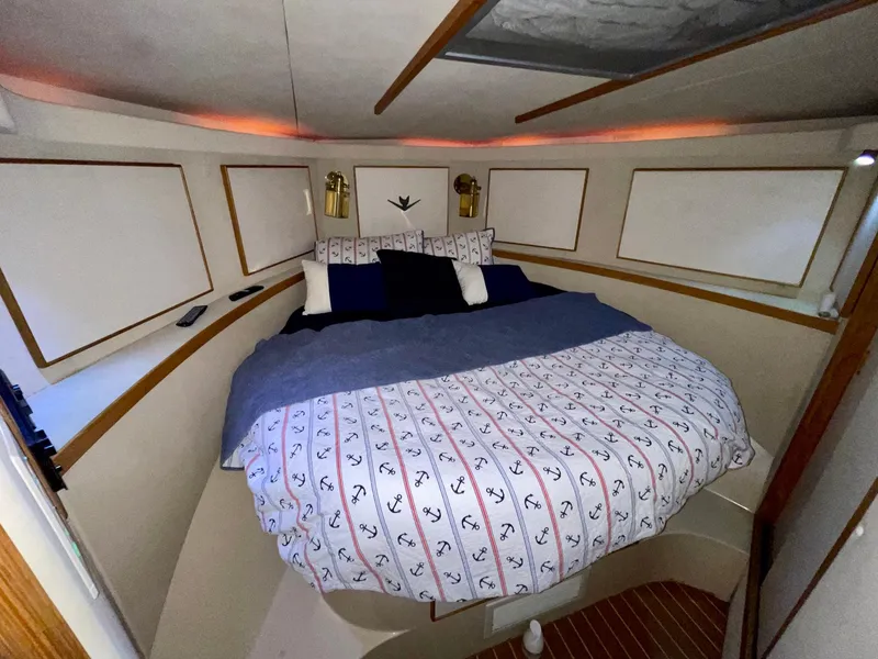 Slide: The Image of 1988 Bertram 43 Convertible cabin with cozy bed and nautical-themed bedding. - 31