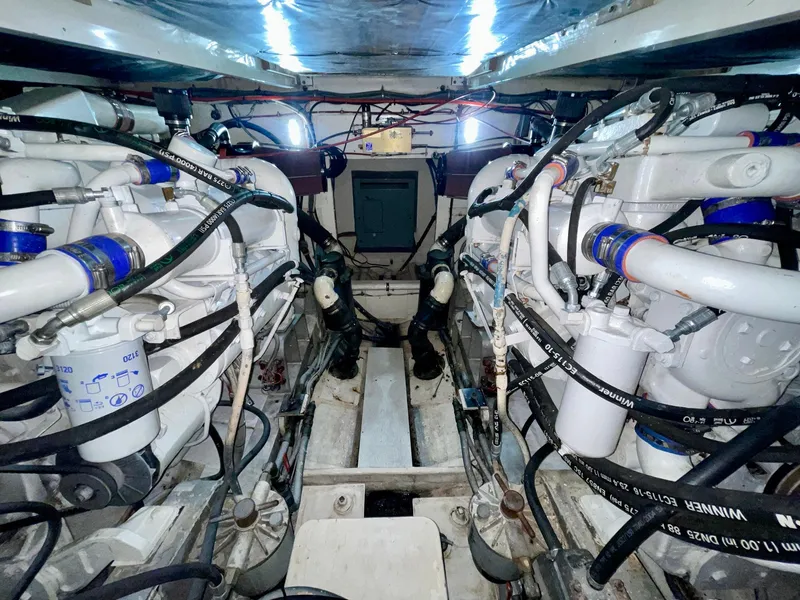 Slide: The Image of Engine room of a 1988 Bertram 43 Convertible boat, showcasing dual engines and mechanical components. - 34