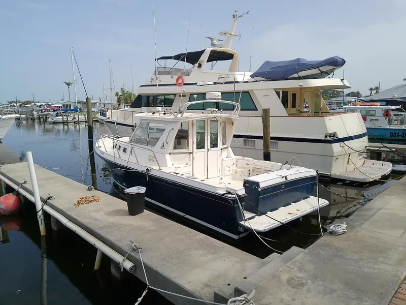 The Image of 1996 Albin 31 Tournament Express docked at marina, alongside larger yacht. - 0