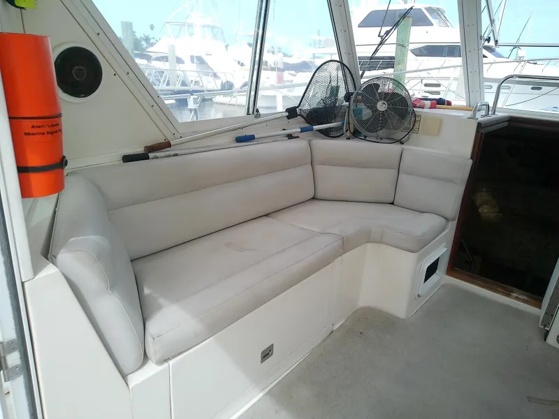 Slide: The Image of 1996 Albin 31 Tournament Express interior with cushioned seating and fishing gear. - 21