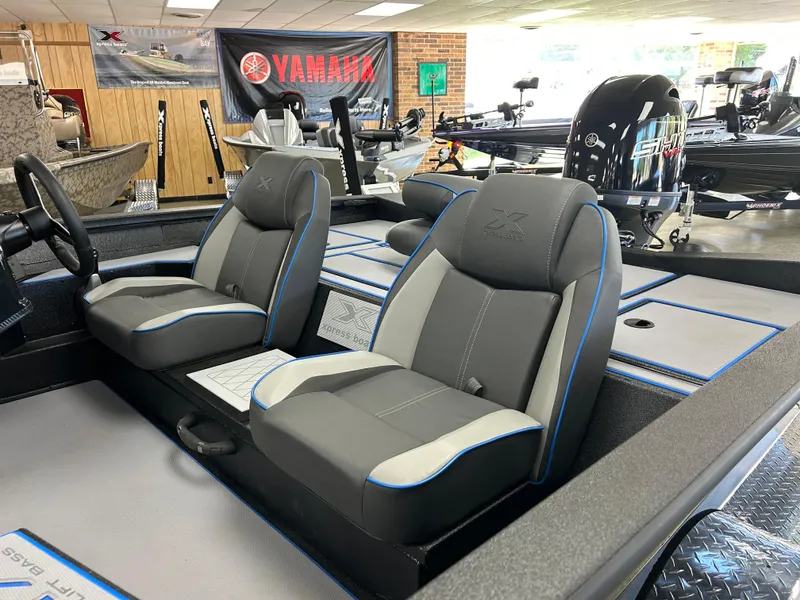 Slide: The Image of 2025 Xpress H17 boat interior with gray and blue seats in showroom. - 4