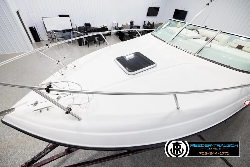 Slide: The Image of 1999 Crownline 242 CR boat in showroom, featuring sleek design and spacious deck. - 10