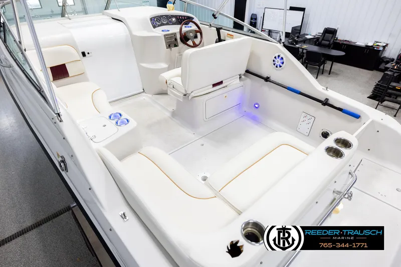 Slide: The Image of 1999 Crownline 242 CR boat interior with white seating and modern dashboard. - 11