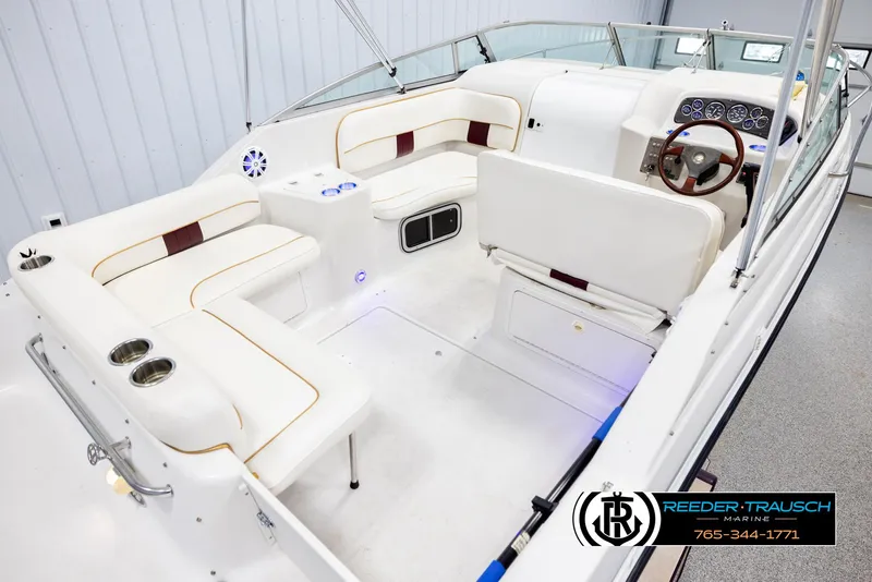 Slide: The Image of 1999 Crownline 242 CR boat interior with white seating and modern dashboard. - 12