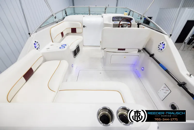 Slide: The Image of 1999 Crownline 242 CR boat interior with white seating and modern dashboard. - 13