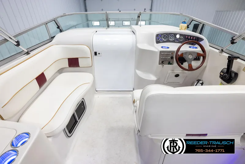 Slide: The Image of 1999 Crownline 242 CR boat interior with white seating and control panel. - 14