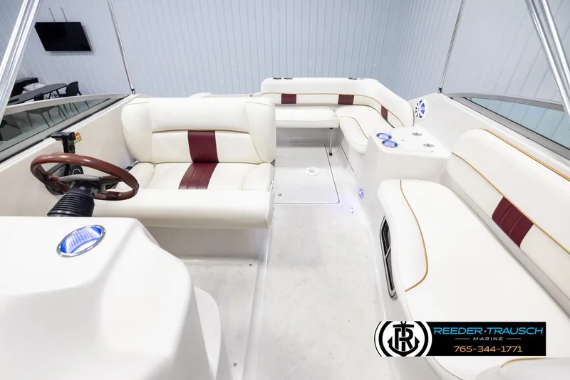 Slide: The Image of 1999 Crownline 242 CR boat interior with white and maroon seating, steering wheel, and modern design. - 18