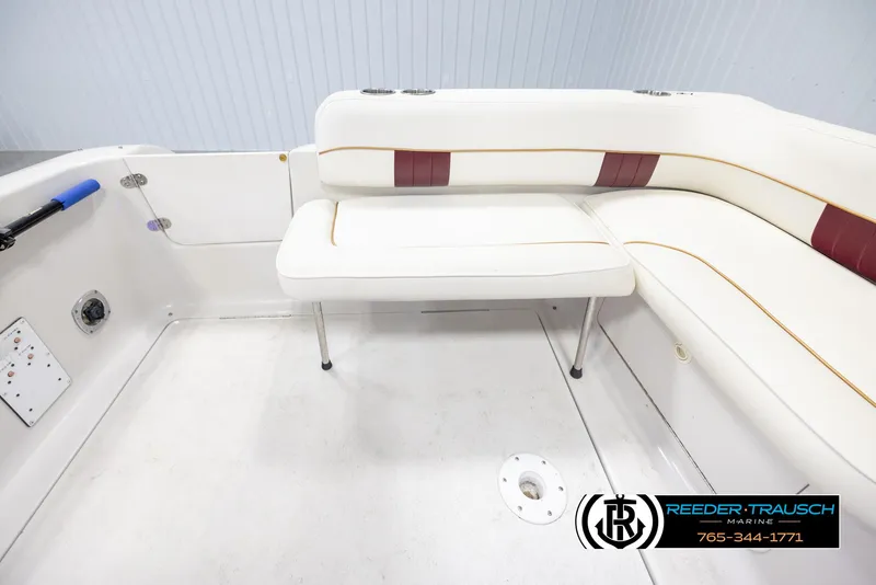 Slide: The Image of 1999 Crownline 242 CR boat interior with white and maroon seating, Reeder-Trausch Marine logo. - 19