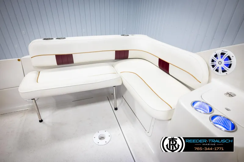 Slide: The Image of 1999 Crownline 242 CR boat interior with white and maroon seating, blue LED cup holders. - 22