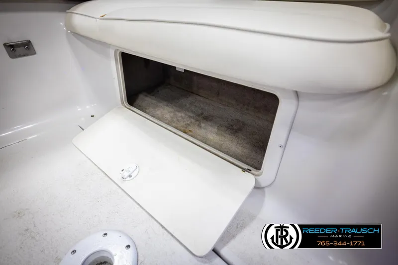 Slide: The Image of 1999 Crownline 242 CR boat storage compartment with open hatch, white interior. - 27