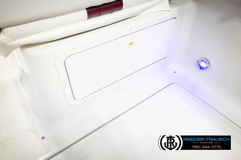 Slide: The Image of 1999 Crownline 242 CR boat interior with storage compartment and blue LED light. - 28