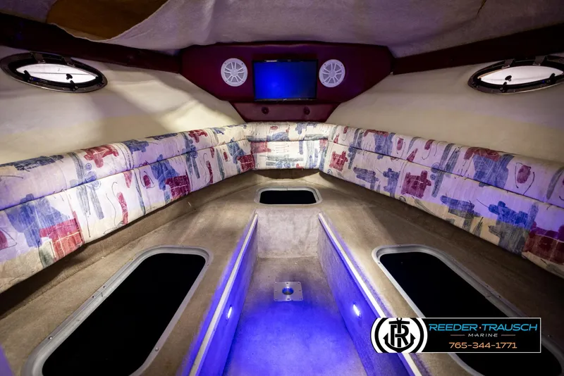 Slide: The Image of 1999 Crownline 242 CR cabin interior with patterned seating and ambient lighting. - 33
