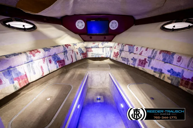 Slide: The Image of 1999 Crownline 242 CR cabin interior with patterned seating and ambient lighting. - 34