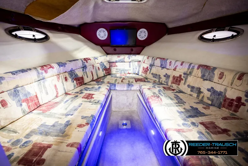 Slide: The Image of 1999 Crownline 242 CR cabin interior with patterned seating and ambient lighting. - 35