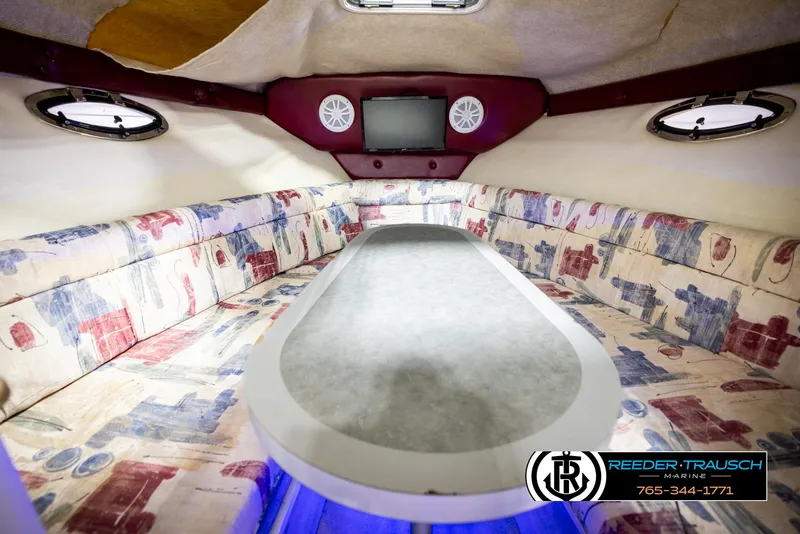 Slide: The Image of 1999 Crownline 242 CR cabin interior with patterned seating and oval table. - 36