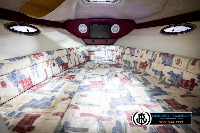 Slide: The Image of 1999 Crownline 242 CR cabin interior with patterned upholstery and porthole windows. - 37