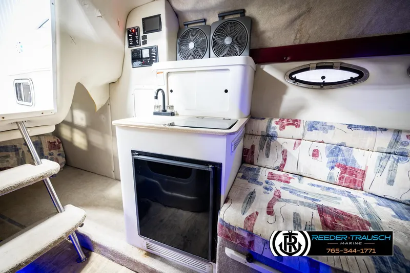 Slide: The Image of 1999 Crownline 242 CR cabin interior with kitchenette, seating, and modern amenities. - 38