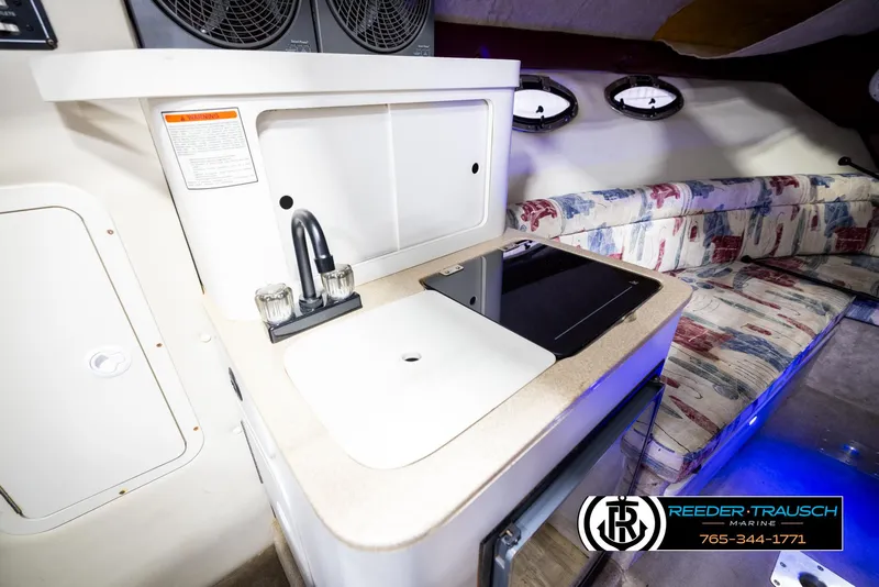 Slide: The Image of 1999 Crownline 242 CR boat interior with kitchenette and seating area. - 39