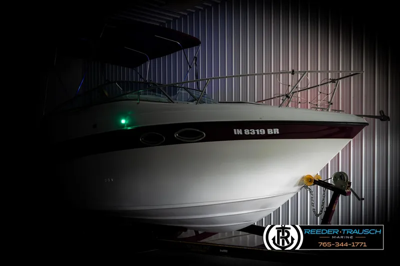 Slide: The Image of 1999 Crownline 242 CR boat in storage, side view with visible registration number. - 4