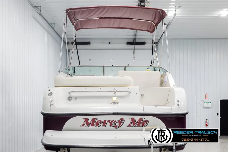 Slide: The Image of 1999 Crownline 242 CR boat with maroon canopy in indoor storage. - 7