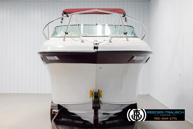 Slide: The Image of 1999 Crownline 242 CR boat with red canopy, displayed indoors at Reeder-Trausch Marine. - 8