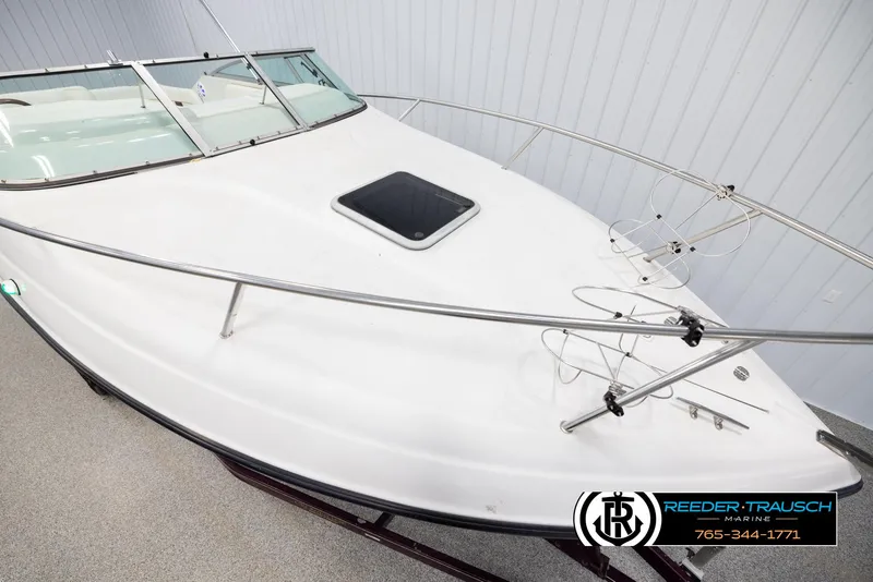 Slide: The Image of 1999 Crownline 242 CR boat, white exterior, docked indoors at Reeder-Trausch Marine. - 9