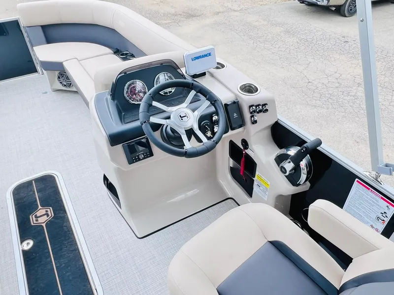 Slide: The Image of 2025 Harris Cruiser 230 boat interior with steering wheel and seating area. - 14