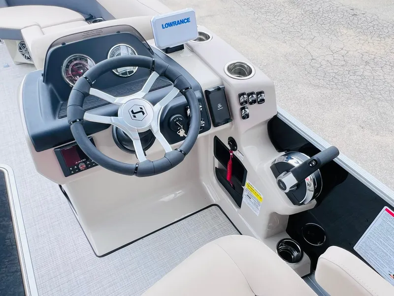 Slide: The Image of 2025 Harris Cruiser 230 boat dashboard with steering wheel and control panel. - 15