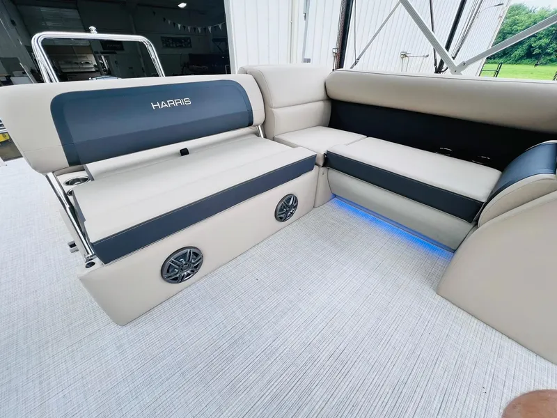 Slide: The Image of 2025 Harris Cruiser 230 interior with beige seating, blue LED lighting, and built-in speakers. - 17
