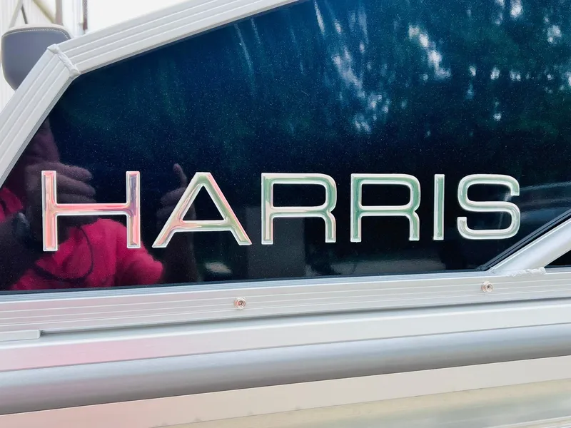 Slide: The Image of 2025 Harris Cruiser 230 boat logo on sleek metallic surface. - 28