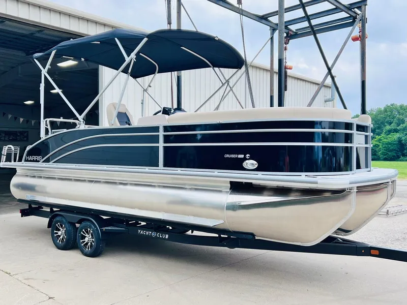 Slide: The Image of 2025 Harris Cruiser 230 pontoon boat on trailer, featuring sleek design and canopy. - 7