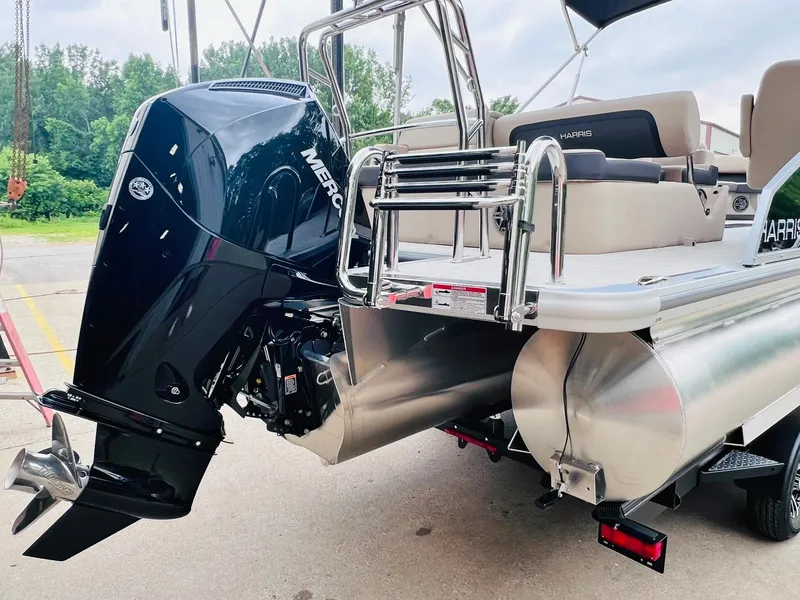 Slide: The Image of 2025 Harris Cruiser 230 pontoon boat with Mercury outboard motor, docked outdoors. - 8