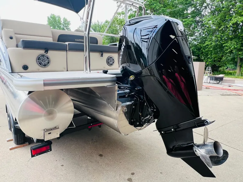 Slide: The Image of 2025 Harris Cruiser 230 pontoon boat with powerful outboard motor, docked on concrete surface. - 9