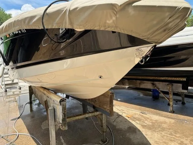 Slide: The Image of 2011 Chaparral 216 SSi boat on stand, covered, with black and white hull. - 3