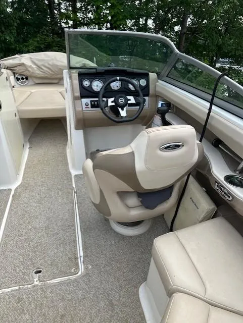 Slide: The Image of 2011 Chaparral 216 SSi boat interior with beige seating and steering console. - 5