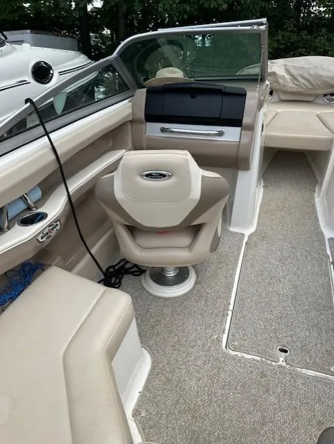 Slide: The Image of 2011 Chaparral 216 SSi boat interior with beige seating and steering console. - 6